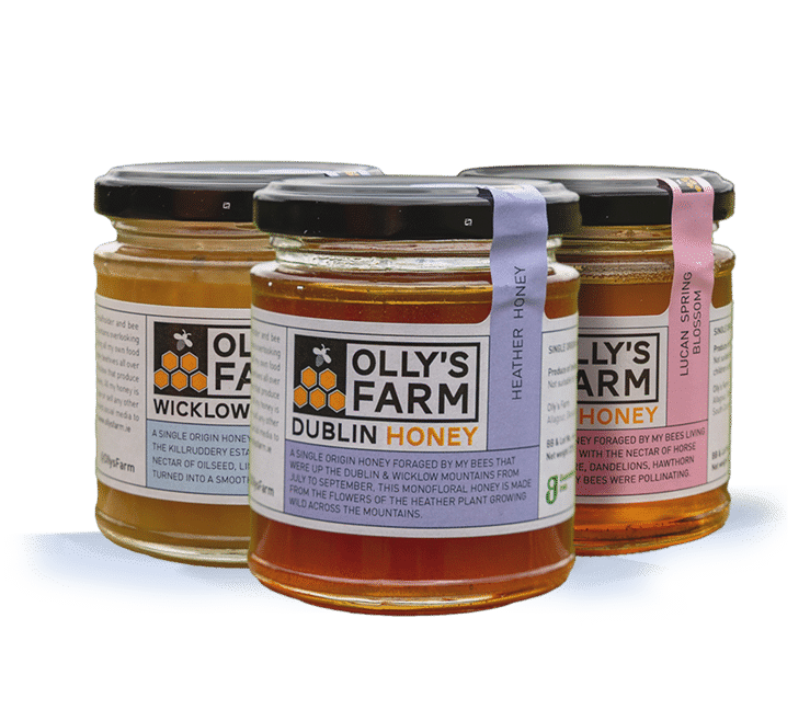 Three jars of Olly’s Farm honey are displayed. Each jar has a different colored label—yellow, purple, and pink—indicating different honey varieties: Wicklow, Dublin, and Lucan Spring.