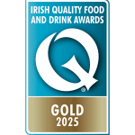 A blue and gold badge displaying a large white "Q" with the text "Irish Quality Food and Drink Awards" above and "Gold 2025" below.